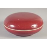 A CHINESE COPPER RED PORCELAIN CIRCULAR BOX AND COVER, six-character mark to base, 14.5cm diameter.