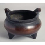 A SUPERB EARLY CHINESE BRONZE TRIPOD CENSER, possibly 17th/18th century, with twin handles, the base