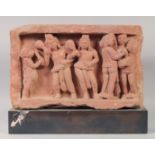 AN INDIAN MATHURA KUSHAN RED STONE CARVED PANEL, depicting kings and aprsa, with mounted base, panel