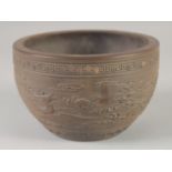 AN UNUSUAL CHINESE YIXING PLANT POT, with relief decoration of dragon and phoenix, 17.5cm diameter.
