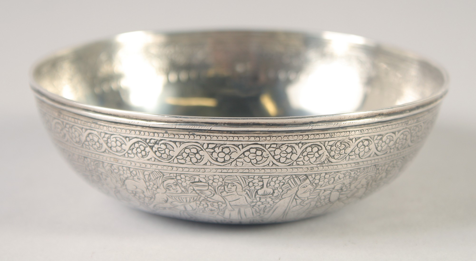 A PERSIAN FINELY ENGRAVED SILVER BOWL, with a band of figures and foliate motifs, weight 80g, 11cm