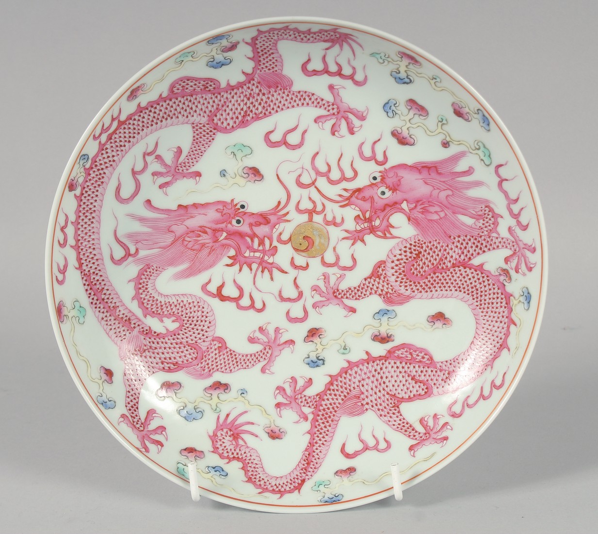 A CHINESE FAMILLE ROSE PORCELAIN DRAGON PLATE, the base with six-character mark, 21cm diameter.