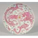 A CHINESE FAMILLE ROSE PORCELAIN DRAGON PLATE, the base with six-character mark, 21cm diameter.