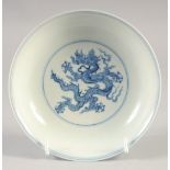 A CHINESE BLUE AND WHITE PORCELAIN DISH, decorated with dragons, bearing six-character mark, 15cm