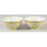 A PAIR OF CHINESE YELLOW GROUND FAMILLE ROSE PORCELAIN BOWLS, decorated with roundels of gilt