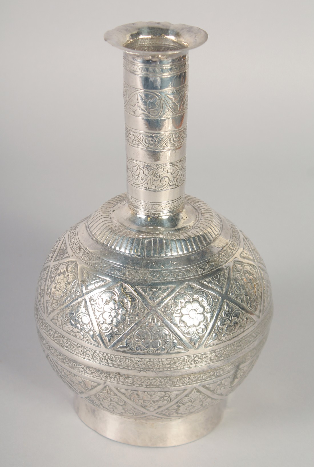 A FINELY ENGRAVED INDIAN OR SOUTH EAST ASIAN WHITE METAL SURAHI BOTTLE, 23cm high.