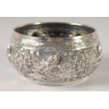 A BURMESE EMBOSSED SILVER BOWL, with relief decoration of figures, weight 155g, 12cm diameter.