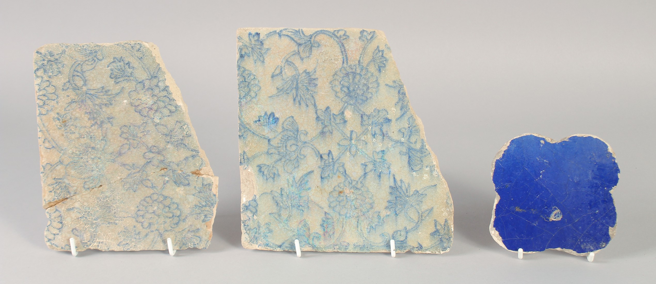 TWO 16TH-17TH CENTURY PERSIAN SAFAVID TILE FRAGMENTS, together with another small Seljuk Kashan