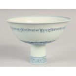 A CHINESE BLUE AND WHITE PORCELAIN STEM BOWL, the exterior with a band of characters, the interior