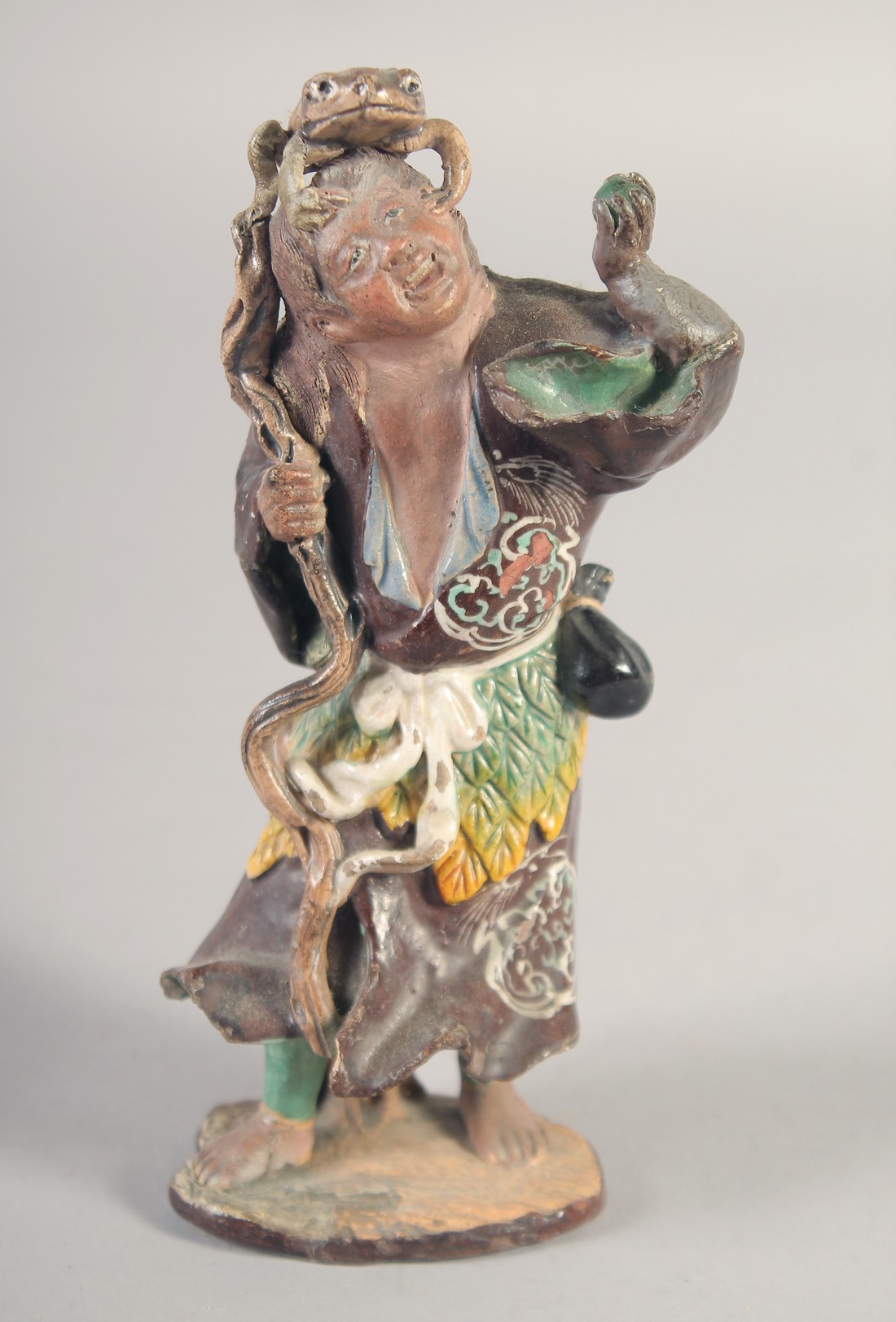 A PAINTED TERRACOTTA FIGURE OF A SENNIN and his three-legged toad, 16.5cm high.