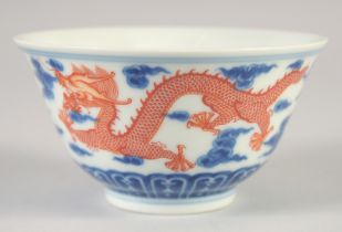 A CHINESE BLUE, WHITE AND IRON RED BOWL, with dragons and stylised clouds, Xuantong mark to base,
