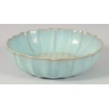 A CHINESE CELADON PETAL FORM BOWL, with carved characters, 22cm diameter.