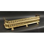 A 19TH CENTURY BRASS FENDER with pierced fretwork front on brass claw feet. 3ft 7ins long, 10ins