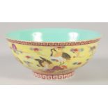 A CHINESE YELLOW GROUND FAMILLE ROSE BOWL decorated with cranes, six character mark to base. 15cm