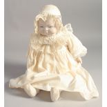 A PORCELAIN HEADED BABY DOLL. 14ins long.
