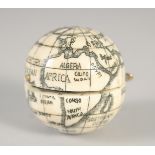 AN ETCHED BONE FOLDING GLOBE COMPASS. 1.5ins diameter.