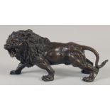 A BRONZE STANDING LION. 11ins long.