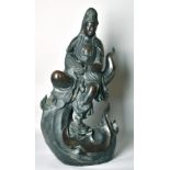 A LARGE CHINESE BRONZE FIGURE OF GUANVIN sitting atop a wave, holding a sceptre, bearing a six-