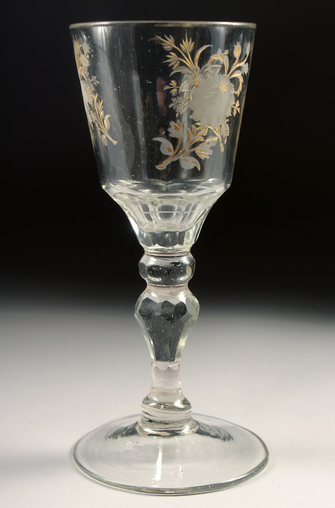 AN 18TH CENTURY DUTCH WINE GLASS with facet stem, the bowl engraved with flowers. 6ins high.