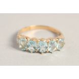 A 9CT GOLD FIVE STONE AQUAMARINE RING.