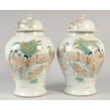 A PAIR OF CHINESE PORCELAIN TEMPLE JAR AND COVER painted with figures. 16ins high.