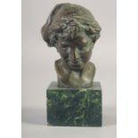 A SMALL BRONZE BUST OF A BOY on a marble base. 3.25ins high.