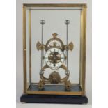 A BRASS SKELETON CLOCK with two enamel dials in a glass case. 19ins high.