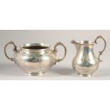 A VICTORIAN ENGRAVED SILVER TWO HANDLED CIRCULAR SUGAR BOWL AND MILK JUG. London 1848. Maker: