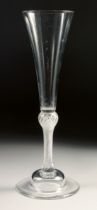 AN 18TH CENTURY TALL PLAIN ALE GLASS with air twist stem. 7.75ins high.