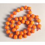 A BUTTERSCOTCH AMBER NECKLACE, forty beads. Weight: 33gms, 20ins long.