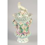 AN 18TH OR 19TH CENTURY VASE AND COVER with bird finial encrusted with flowers and face-mask