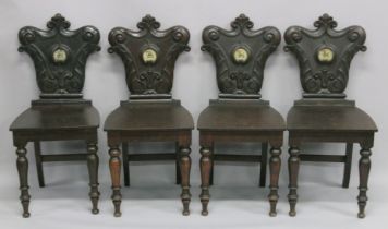 A VERY GOOD SET OF FOUR REGENCY HALL CHAIRS with carved shaped backs with crest, solid seats on