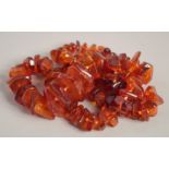 AN AMBER NECKLACE with graduated beads. 26ins long.