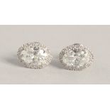 A SUPERB PAIR OF 18CT WHITE GOLD OVAL DIAMOND SET EARRINGS, the central diamonds 1.03ct to 1.02ct.