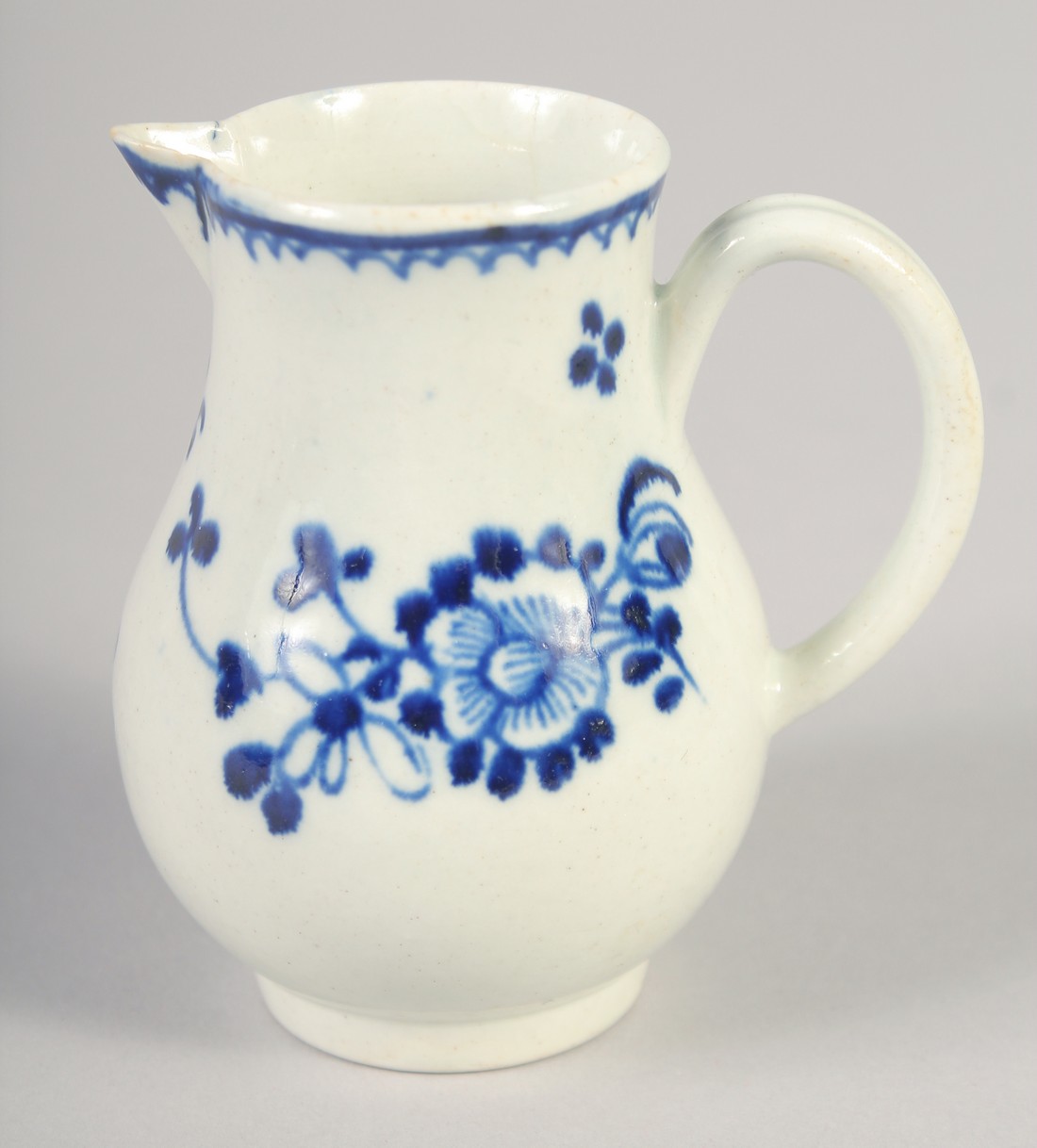 AN 18TH CENTURY LIVERPOOL JUG painted in underglaze blue with flowers with external line and loop