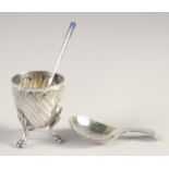 A SMALL ART NOUVEAU SILVER EGG CUP on three claw feet, blue enamel spoon. George III silver caddy