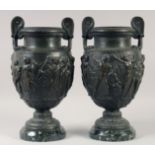A VERY GOOD PAIR OF CLASSICAL SKIMMED BRONZE TWO HANDLED URNS with a band of classical figures, on a