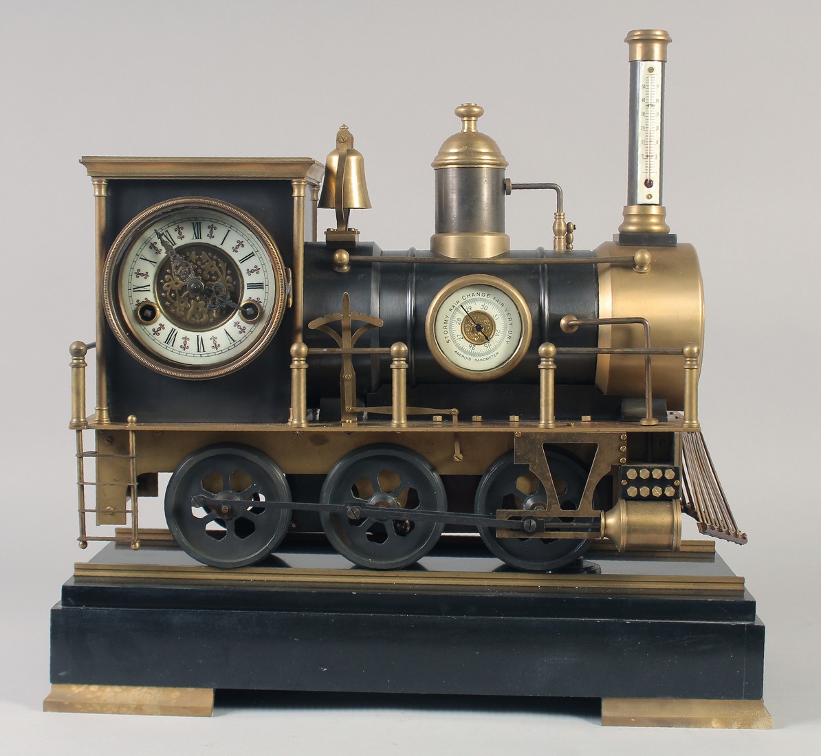 A GOOD BRONZE TRAIN CLOCK on a stand with three dials. 16ins long.