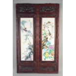 A PAIR OF UPRIGHT CHINESE PORCELAIN PANELS, birds and flowers in wooden frames.