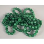 A LONG JADE STRING OF BEADS 50ins long.