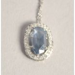 AN 18CT WHITE GOLD AQUAMARINE DIAMOND OVAL PENDANT on a chain,