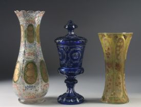 THREE VARIOUS BOHEMIAN GLASS VASES one with a cover. 13ins, 10ins & 9.5ins high.