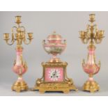 A SUPERB LOUIS XVI GILT BRONZE AND PINK PORCELAIN CLOCK GARNITURE DE CHEMINEE. The clock with Madame