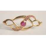 A 9CT GOLD RUBY SET BROOCH.
