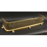 A 19TH CENTURY BRASS FENDER with pierced fretwork front on brass claw feet. 4ft long 11ins deep.