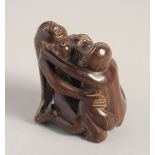 A CARVED WOOD EROTIC NETSUKE, signed. 1.5ins.