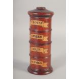 A WOODEN CIRCULAR SPICE TOWER " Cloves, Ginger, Mace, Nutmeg". 7ins high.
