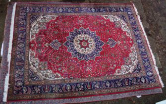 A GOOD LARGE PERSIAN CARPET, crimson ground with floral decoration in a similar blue ground