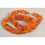 AN AMBER NECKLACE with graduated beads. 24ins long.