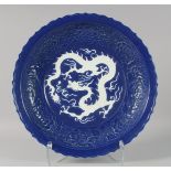 A LARGE CHINESE SACRIFICIAL BLUE DRAGON CHARGER, the centre with carved dragon in white;